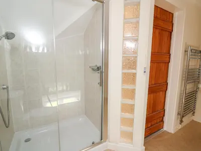 a bathroom with a shower with a glass door at Railway Station Cottage in Llandrindod Wells
