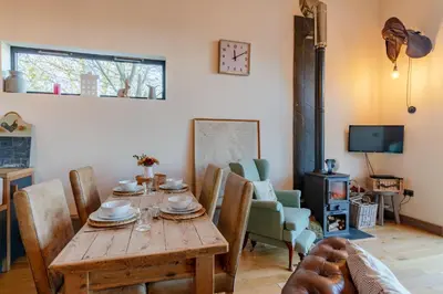 a dining room with a wooden table and chairs at Outshot Barn in Hay-on-Wye