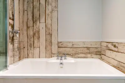 a bathroom with a white bath tub with a mirror at Outshot Barn in Hay-on-Wye
