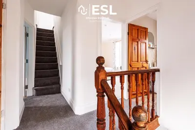 a staircase in a home with a wooden railing at 4 Bedroom House. Close to Shrewsbury Town Centre in Shrewsbury