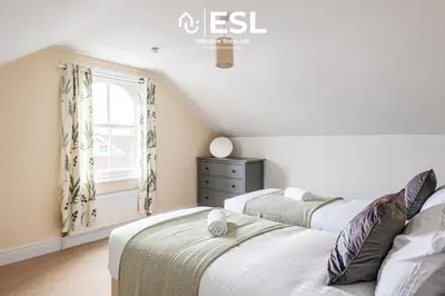 two beds in a room with a window at 4 Bedroom House. Close to Shrewsbury Town Centre in Shrewsbury