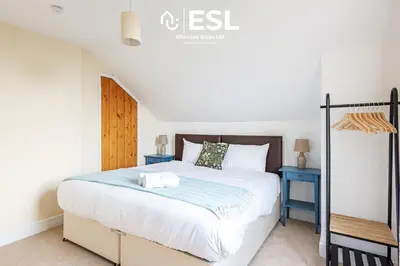 a bedroom with a large bed and a blue nightstand at 4 Bedroom House. Close to Shrewsbury Town Centre in Shrewsbury