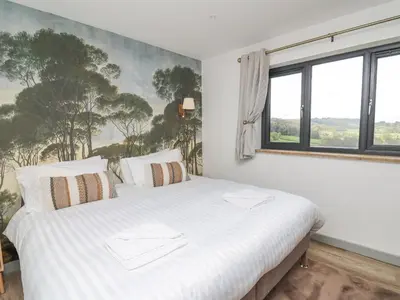 a white bed in a room with a large window at Barcud Coch - Red Kite in Welshpool