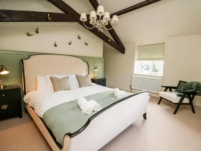 a bedroom with a large bed with towels on it at Dant Y Llew in Bow Street