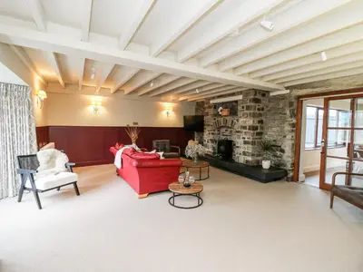 a living room with a red couch and a fireplace at Dant Y Llew in Bow Street