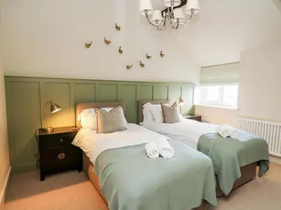 a bedroom with two beds with towels on them at Dant Y Llew in Bow Street