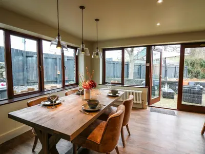a dining room with a wooden table and chairs at Dant Y Llew in Bow Street