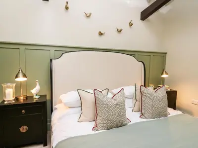 a bedroom with a large white bed with pillows at Llygad Y Dydd in Bow Street