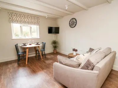a living room with a couch and a table at Llygad Y Dydd in Bow Street
