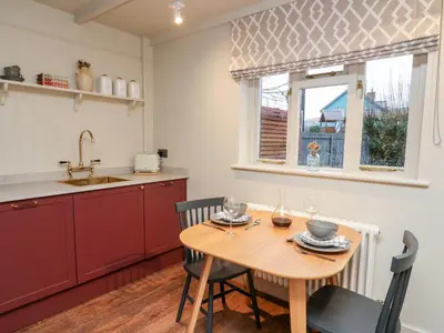 a kitchen with a table and a sink and a window at Llygad Y Dydd in Bow Street