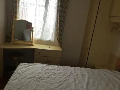 a bedroom with a bed and a mirror and a window at H2 in Aberystwyth