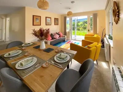 a living room with a wooden table and chairs at The Old Stables in Presteigne