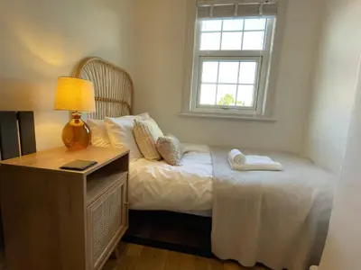 a bedroom with a bed with a lamp and a window at Benyon Street Townhouse in Shrewsbury