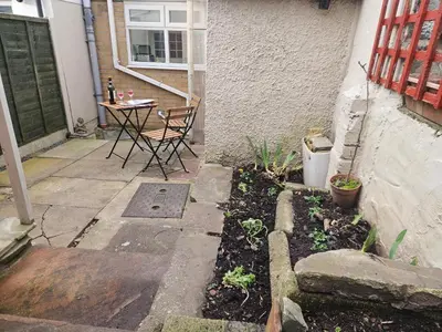 a patio with a table and chairs in a yard at Rhif Deg in Brecon