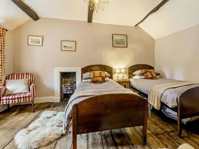 a bedroom with two beds and a chair at 3 Bed in Clyro 88077 in Clyro