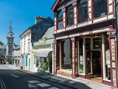 a row of shops on a city street with a clock tower at 3 Bed in Clyro 88077 in Clyro