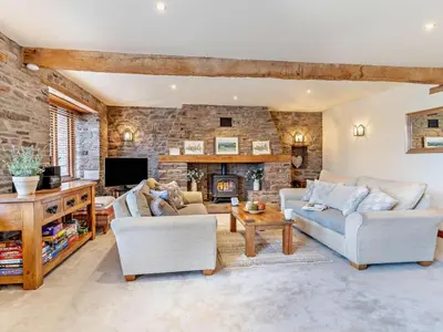 a living room with two couches and a stone wall at 3 Bed in Brecon oc-bn430 in Llangorse