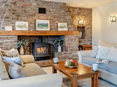 a living room with a fireplace and a stone wall at 3 Bed in Brecon oc-bn430 in Llangorse