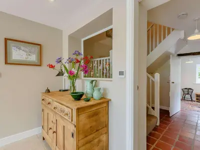 a vase of flowers on a wooden dresser in a hallway at 4 Bed in Oswestry oc-87477 in Llansilin