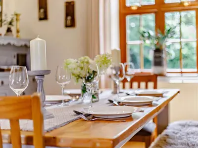a dining room table with a candle and plates and glasses at 4 Bed in Hereford oc-44213 in Hereford