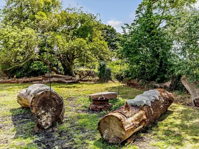 a group of logs in a field with trees at 4 Bed in Hereford oc-44213 in Hereford