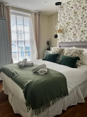 a bedroom with a large bed with towels on it at Isfryn, holiday home in Aberdyfi in Aberdyfi