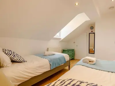 two beds in a room with an attic at The Penthouse Westhaven Aberdyfi in Aberdyfi