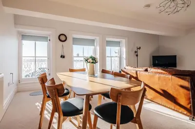 a dining room with a wooden table and chairs at The Penthouse Westhaven Aberdyfi in Aberdyfi
