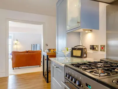 a kitchen with a stove top oven next to a kitchen sidx sidx at The Penthouse Westhaven Aberdyfi in Aberdyfi