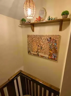 a staircase with a painting on the wall and a stair case at Maytree Cottage. Compact home in Mid Wales. in Llanrhaeadr-ym-Mochnant