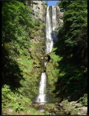 a waterfall on the side of a mountain at Maytree Cottage. Compact home in Mid Wales. in Llanrhaeadr-ym-Mochnant
