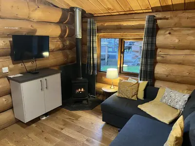 a living room with a couch and a tv and a fireplace at Mountain Edge Resort Lodge 1 with Hot Tub in Church Stretton