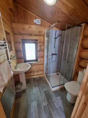 a bathroom with a shower and a toilet and a sink at Mountain Edge Resort Lodge 3 with Hot Tub in Church Stretton