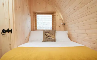 a bedroom with a bed in a wooden room at Mountain Edge Resort Mega pod 1 with Hot Tub in Church Stretton