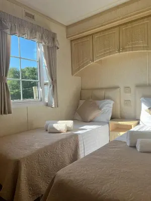 a bedroom with two beds and a window at Heavenly Retreat in Lampeter