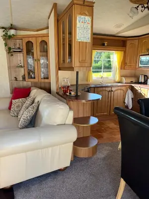 a living room with a white couch and a kitchen at Heavenly Retreat in Lampeter
