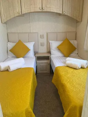 two beds in a small room with yellow sheets at Heavenly Retreat in Lampeter