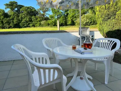 a white table and chairs with an umbrella at Heavenly Retreat in Lampeter