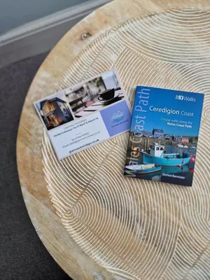 a wooden table with two brochures on top of it at Polruan - stunning central NQ house - dog friendly in New Quay