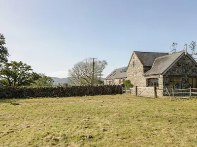 a house with a fence in front of a field at Pandy Farmhouse - Panoramic mountain views within Snowdonia's National Park - 4x4 Only in Dolgellau