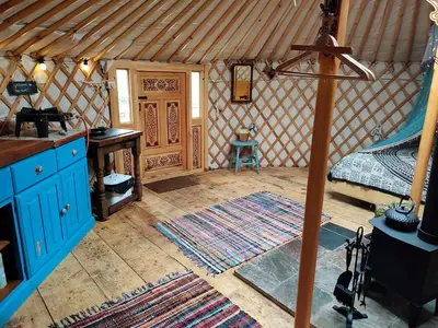 a room with a bed and a desk in a yurt at Traditional Mongolian Yurt - Panoramic Mountain Retreat - 4x4 only in Dolgellau