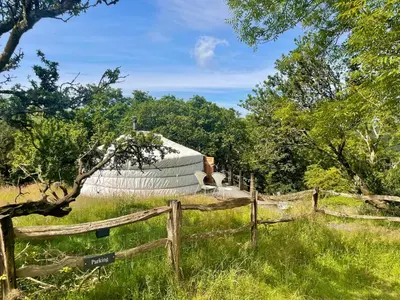 a barn in a field with a fence at Traditional Mongolian Yurt - Panoramic Mountain Retreat - 4x4 only in Dolgellau