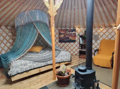 a bedroom with a canopy bed in a yurt at Traditional Mongolian Yurt - Panoramic Mountain Retreat - 4x4 only in Dolgellau