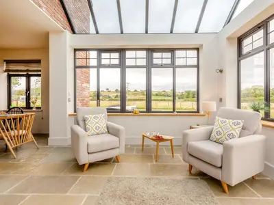 a living room with two chairs and windows at 5 Bed in Llanymynech oc-80686 in Llanymynech