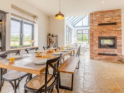 a dining room with a long table and chairs and a fireplace at 5 Bed in Llanymynech oc-80686 in Llanymynech