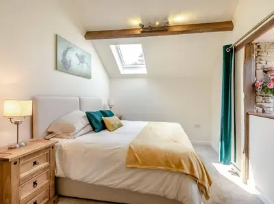 a bedroom with a bed and a dresser and a window at The Barrels at Leintwardine in Leintwardine