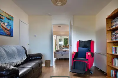 a living room with a couch and a red chair at Finest Retreats - 37 Bro Enddwyn in Dyffryn