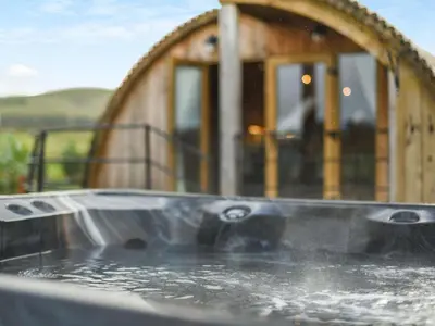 a hot tub filled with water in front of a house at 2 Bed in Rhayader oc-90279 in Saint Harmon