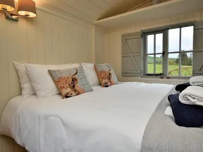 a bedroom with a large white bed with two tigers pillows at 1 Bed in Rhayader oc-90277 in Saint Harmon