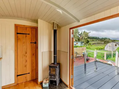 an open door to a porch with a wood stove at 1 Bed in Rhayader oc-90284 in Saint Harmon
